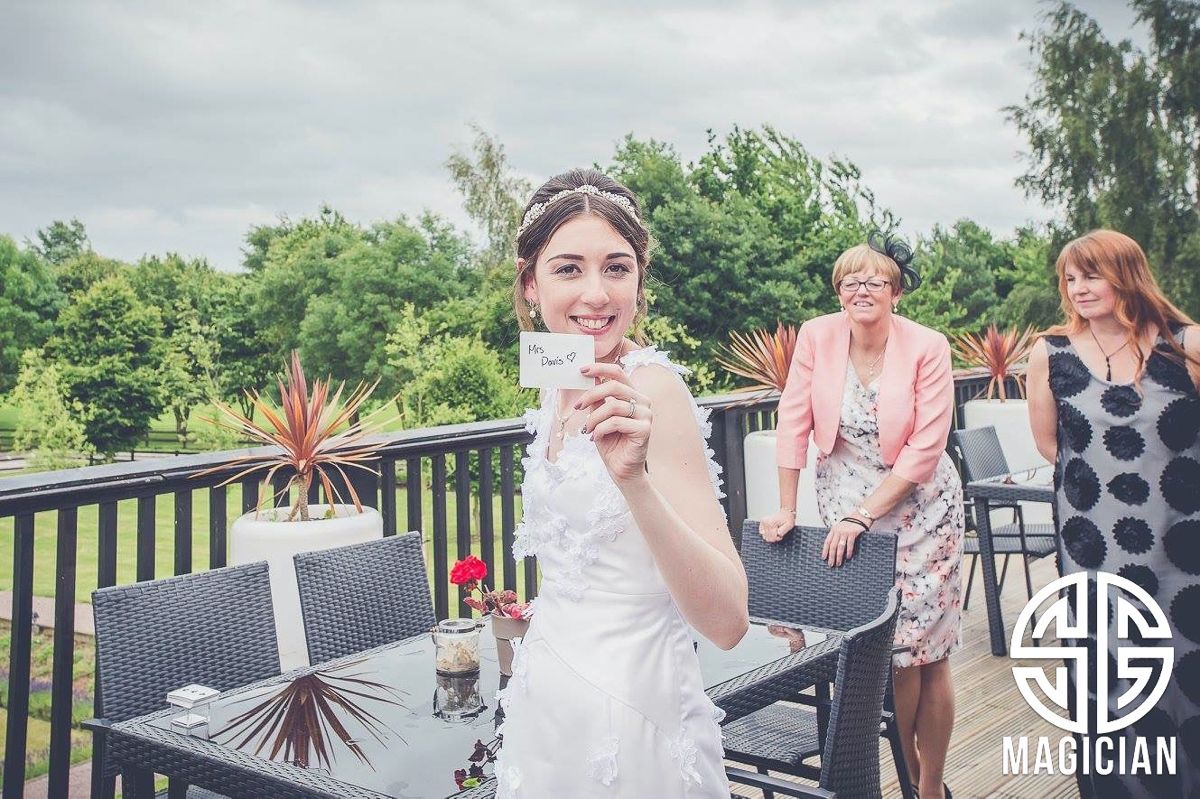 Outdoor wedding celebration on a deck with scenic greenery in the background.