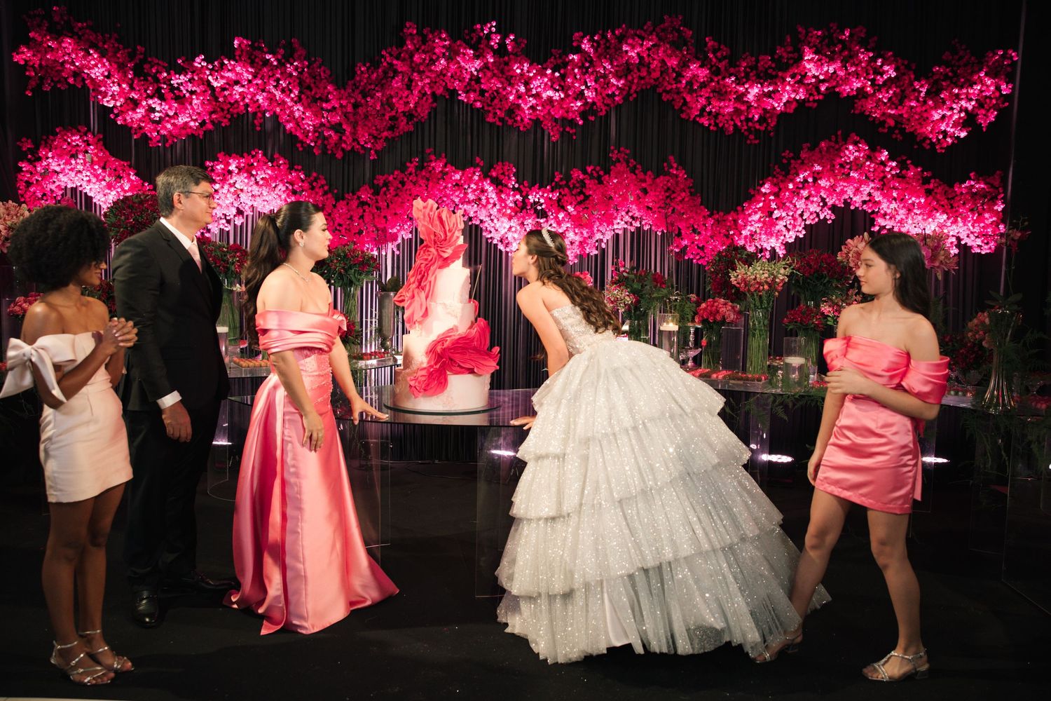 Celebration scene with pink cherry blossom decor and formal attire at an elegant evening event.