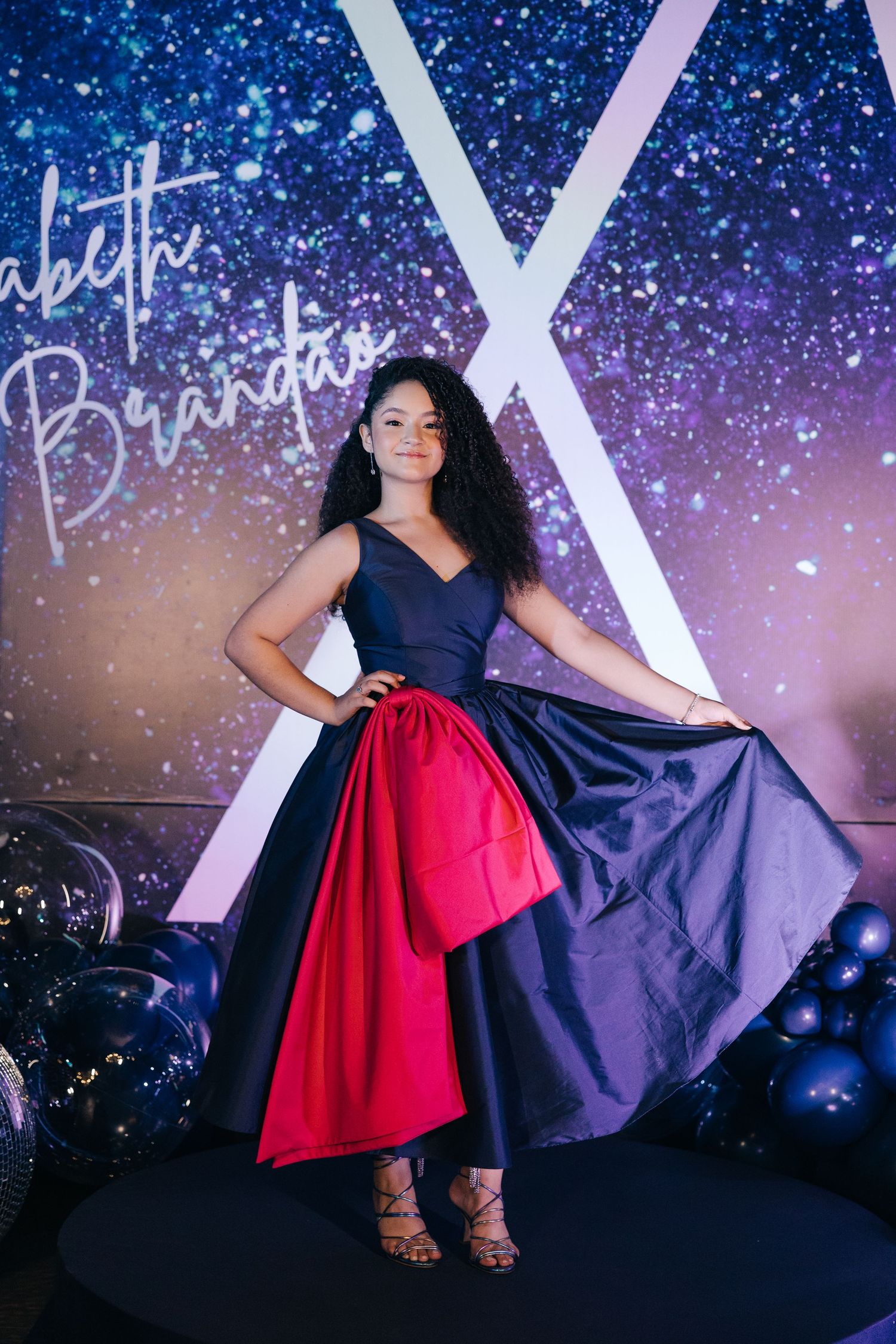 A stunning navy and red color-block evening gown photographed against a sparkly backdrop.
