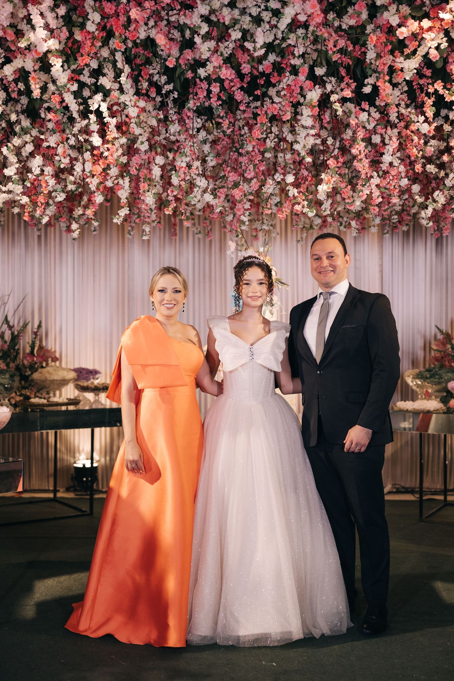 Elegant wedding scene with floral ceiling decorations and formal attire at an indoor venue.