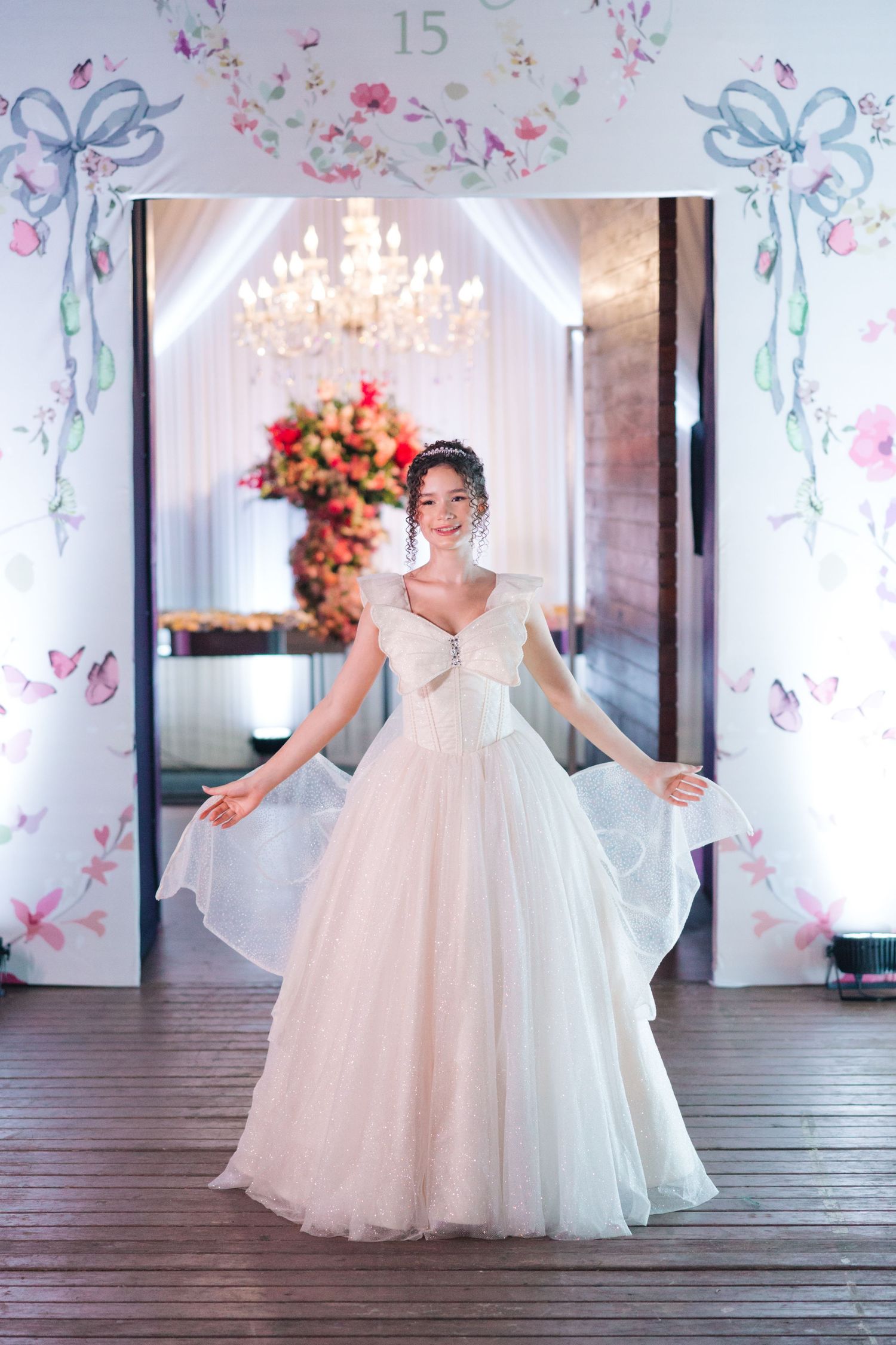Classic ballgown wedding dress showcased in romantic venue with chandelier and floral archway.