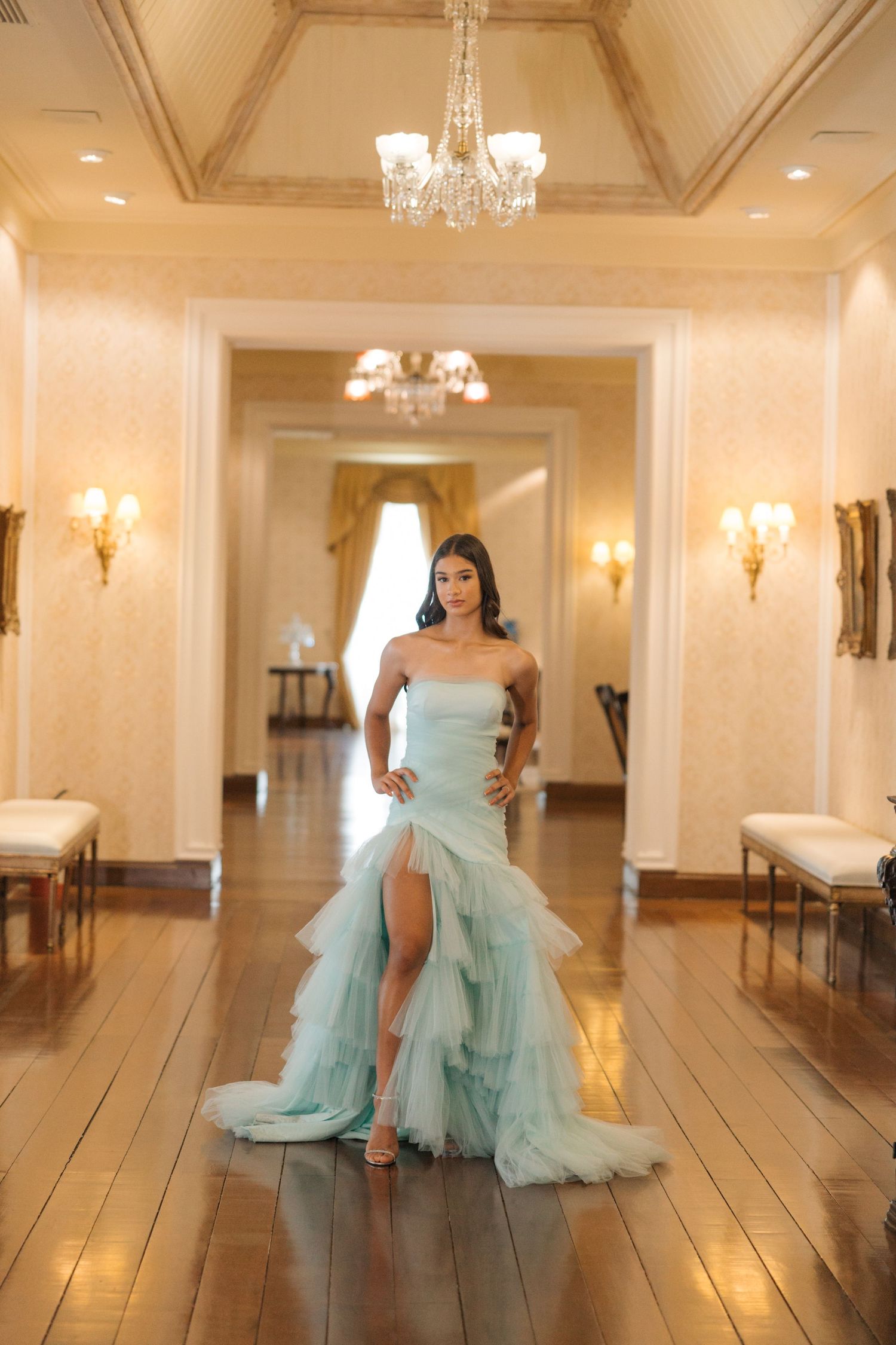Ethereal mint-colored gown with dramatic train photographed in luxurious interior with crystal chandelier.