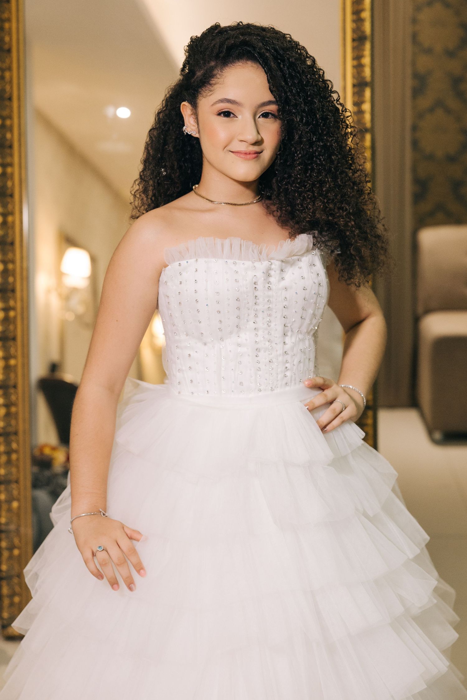 A beautiful white wedding gown with a beaded bodice and layered tulle skirt showcased in an elegant setting.