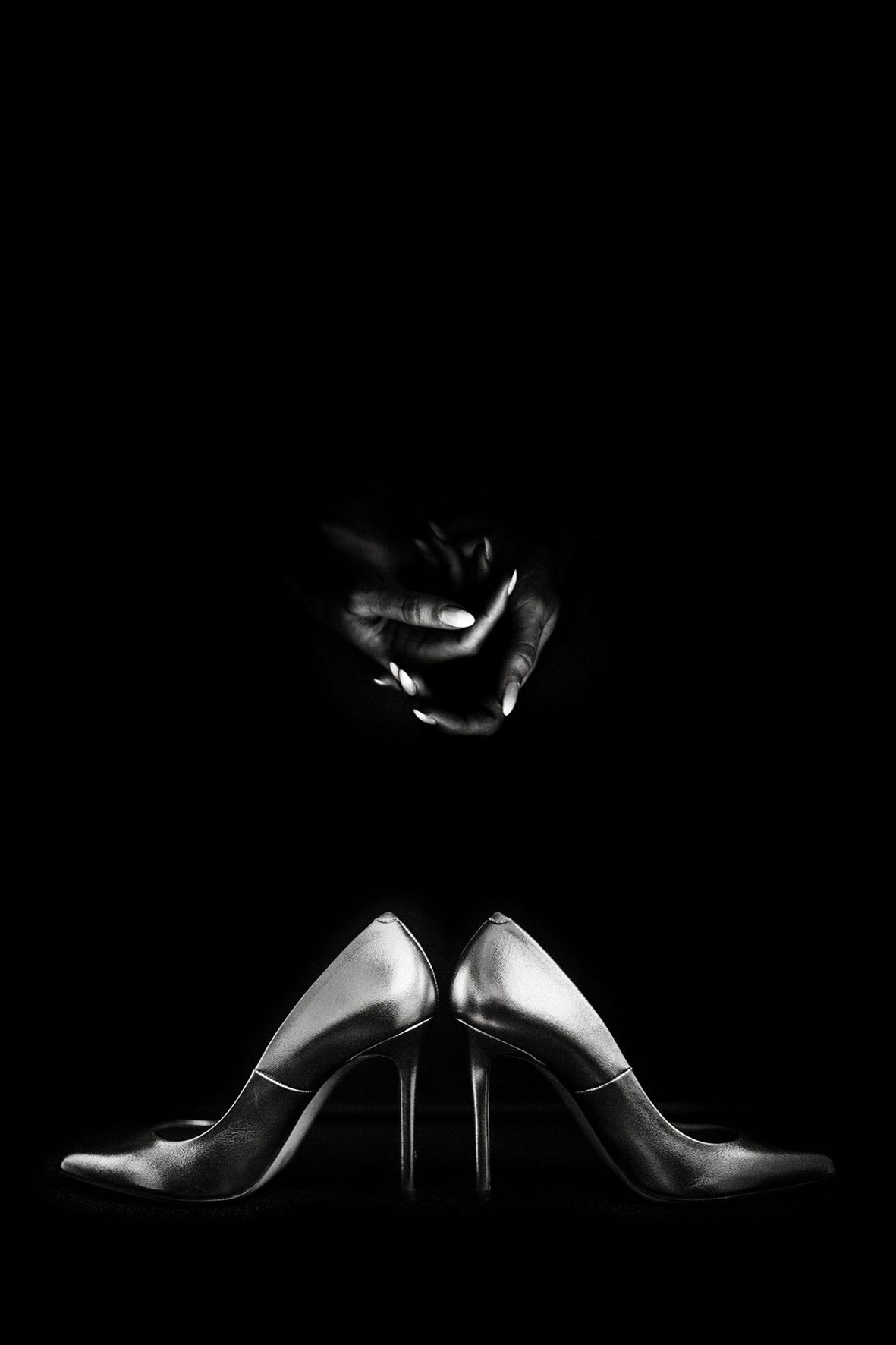 Artistic still life of elegant high heel shoes in dramatic low key lighting.