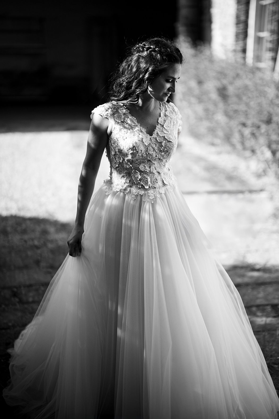 A series of black and white photos showing the flowy skirt of an elegant wedding dress with floral lace details.