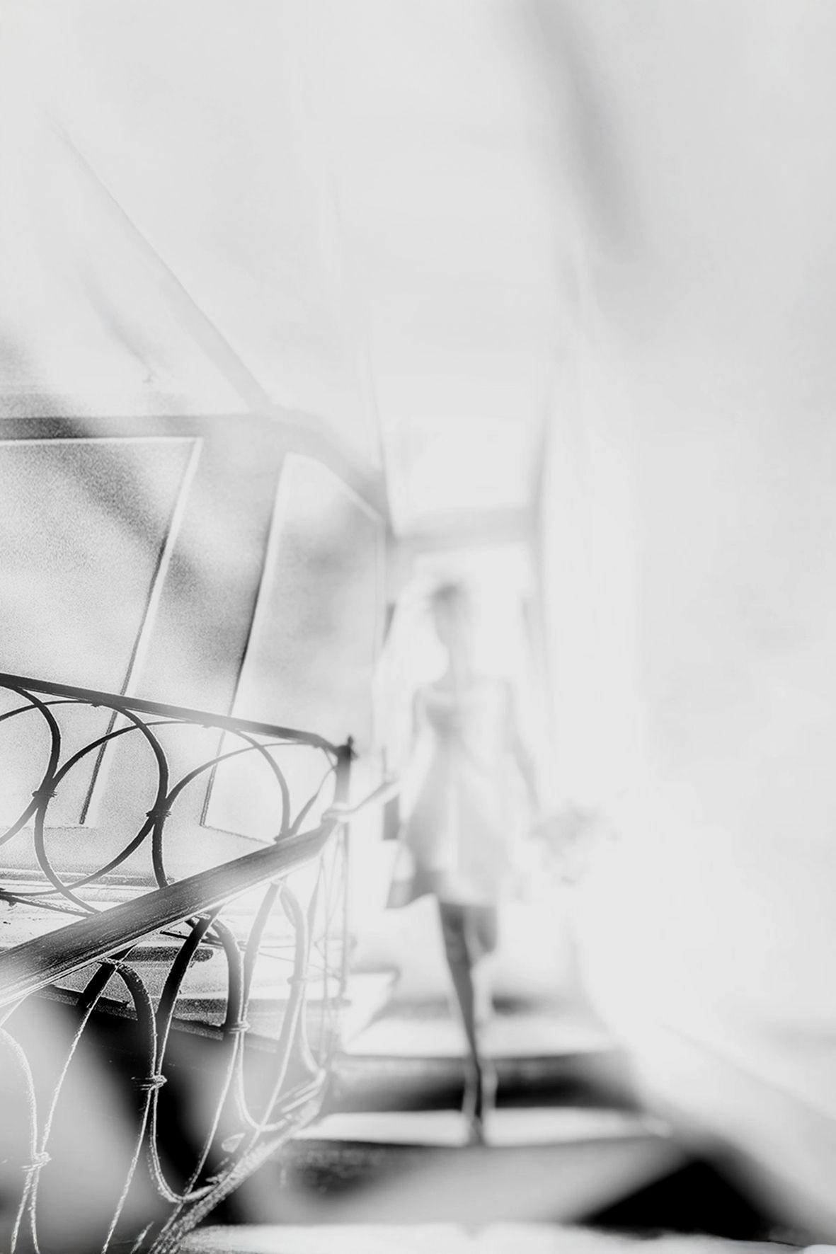 Black and white blurred photograph of chairs lined up in a row with soft focus creating an abstract architectural feel.