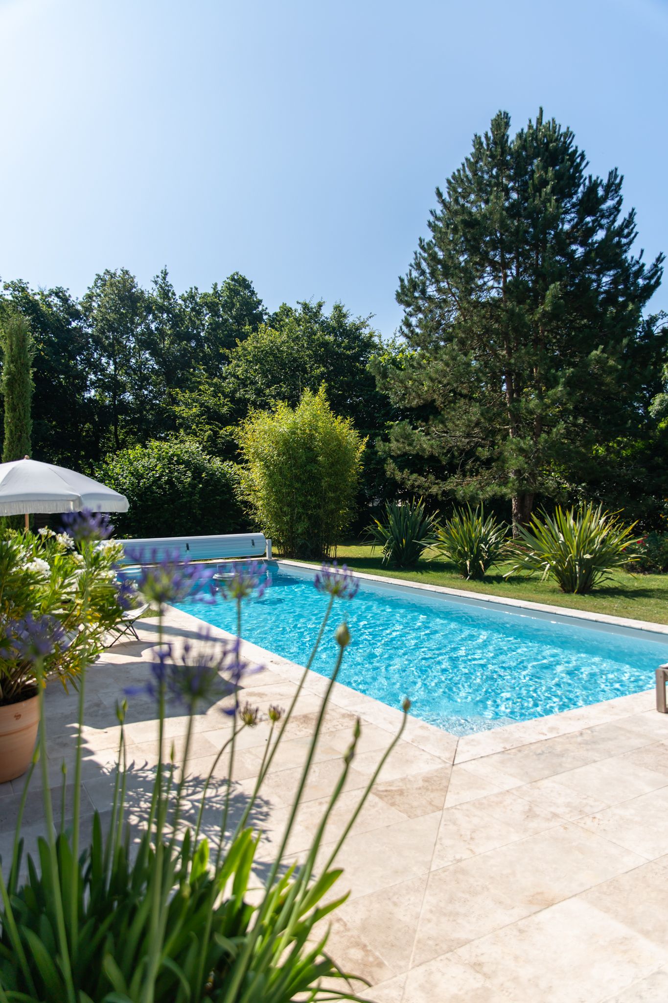 Façade moderne d’une villa avec piscine et jardin paysager.
