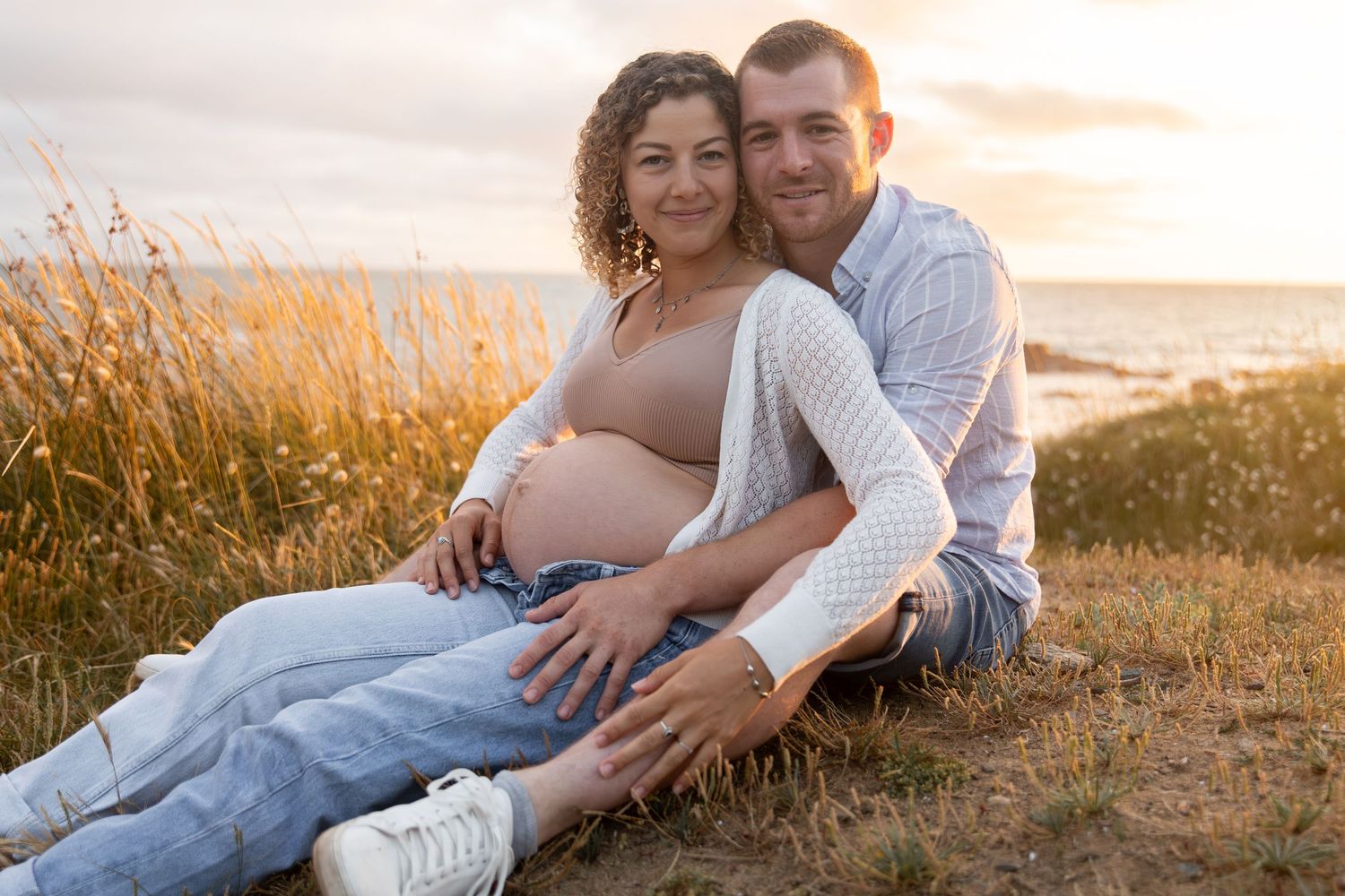 Portrait de couple en attendant bébé, lumière naturelle et tendresse.