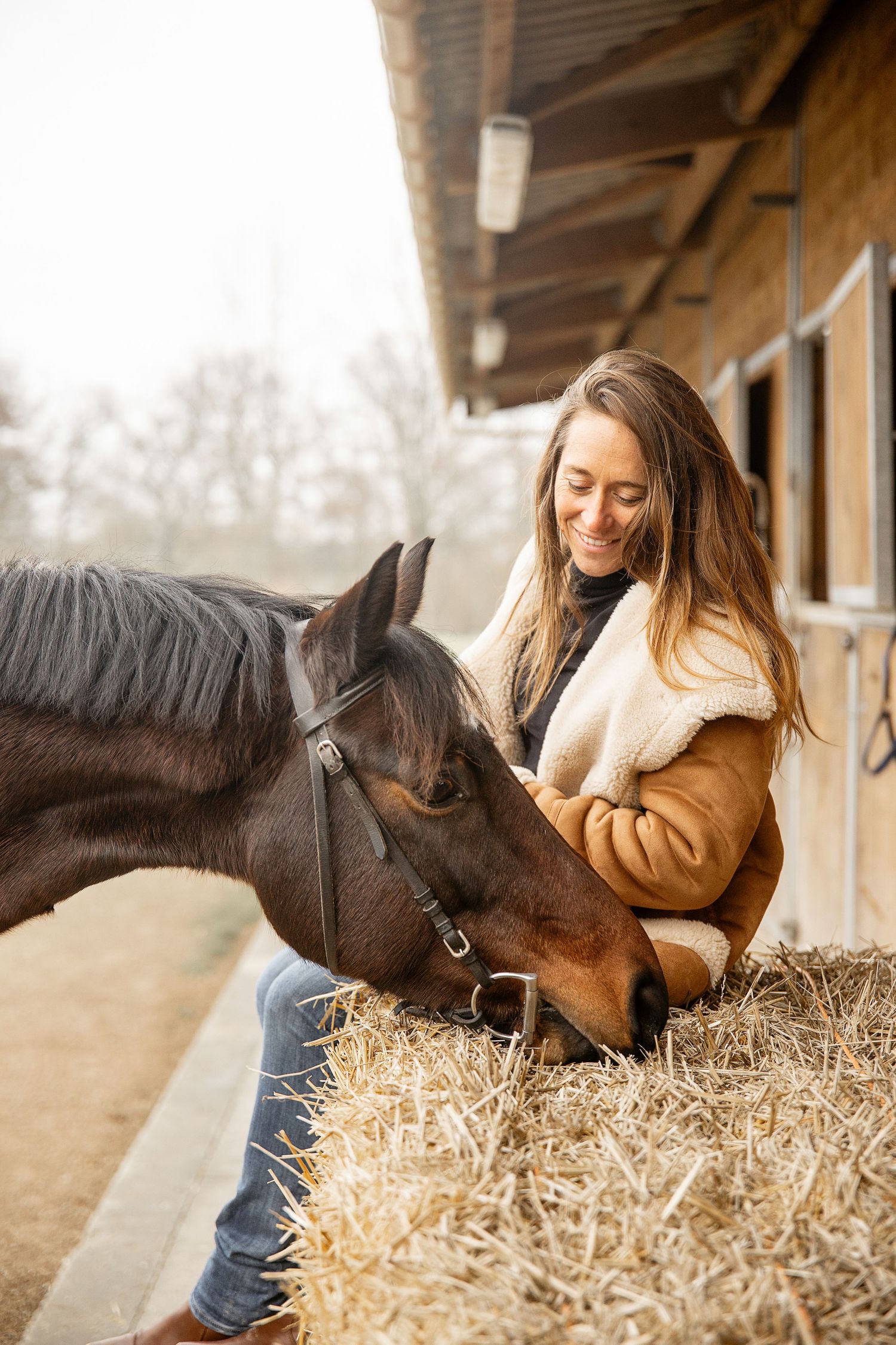 Photo d’une femme en compagnie de son cheval, moment de complicité et de sérénité capturé en extérieur.