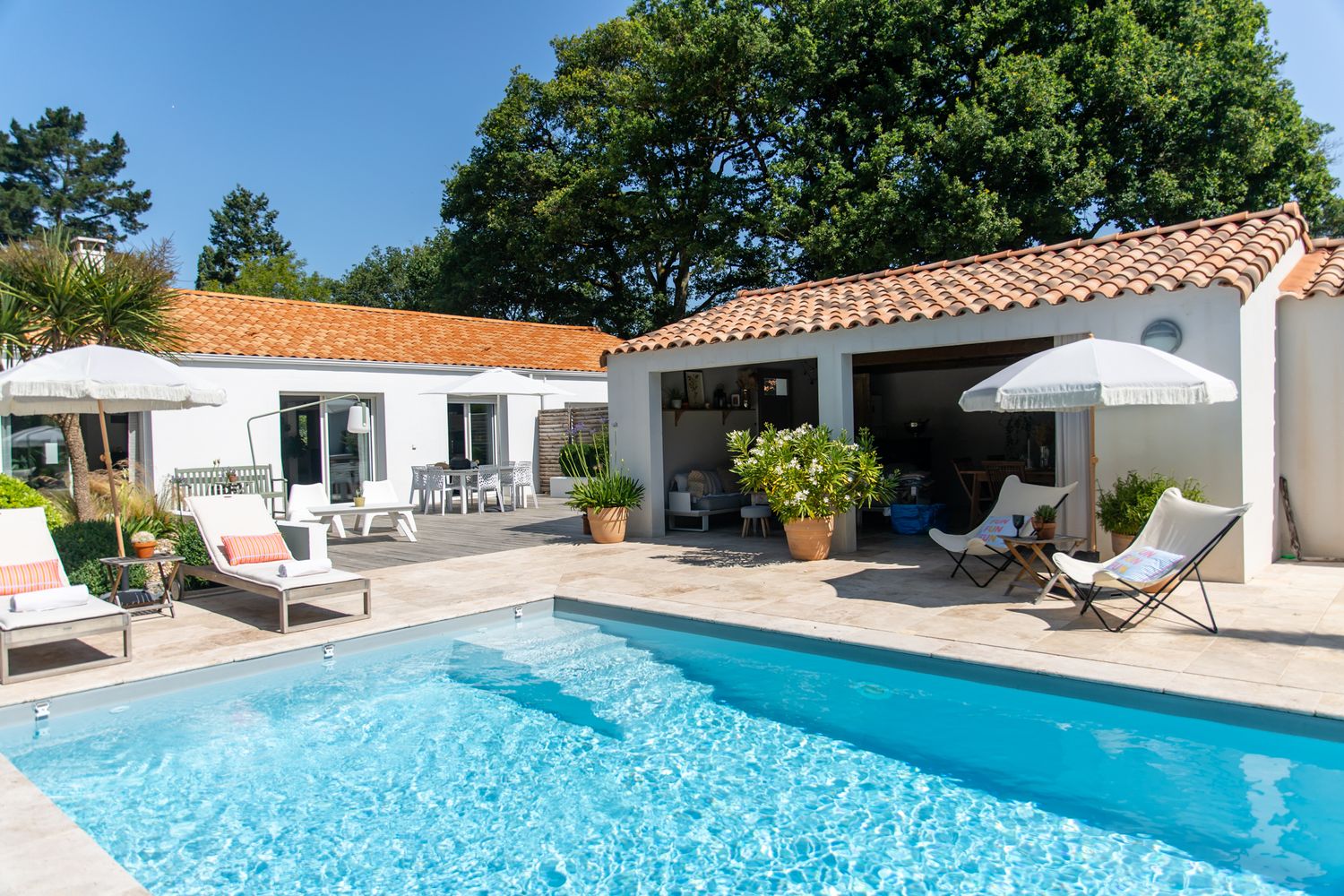 Façade moderne d’une villa avec piscine et jardin paysager.