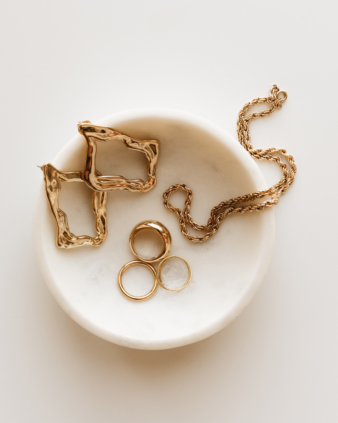Photo en packshot de bijoux, mise en valeur des détails et du design sur fond neutre et lumineux.