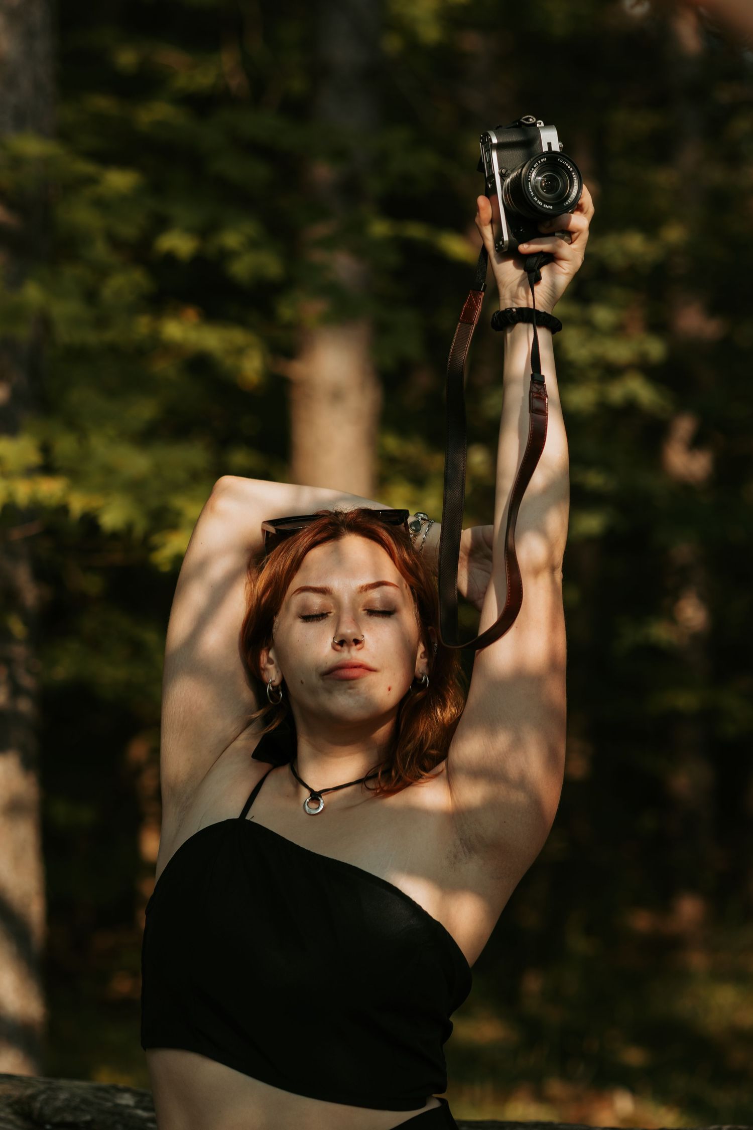 Artistic outdoor portrait sequence with dramatic shadows and raised arms against forest backdrop.