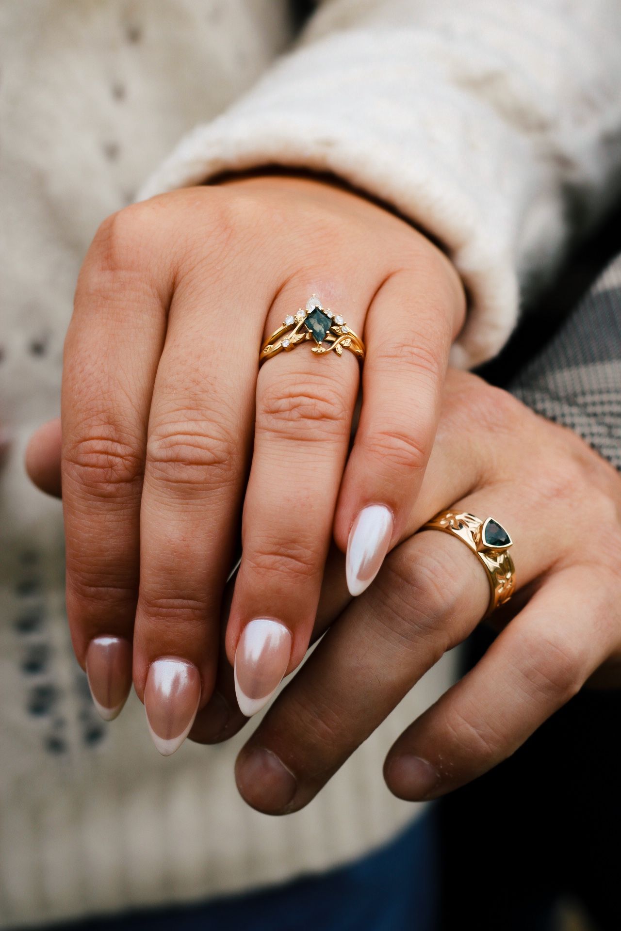 Two elegant rings adorned with turquoise stones displayed on manicured hands with pearlescent nail polish.