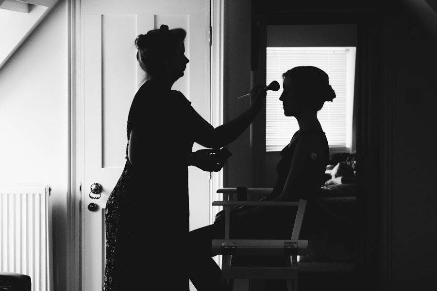 Silhouette of two people getting ready in front of a window in dramatic black and white.