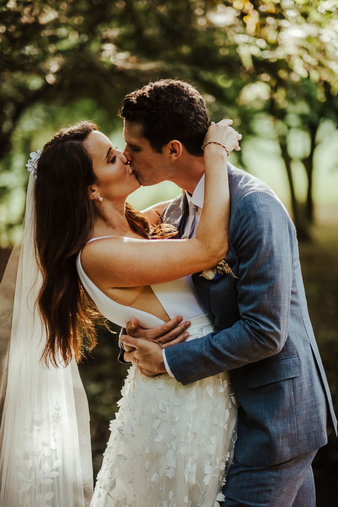 Romantic sunset wedding portrait with couple embracing in golden light.