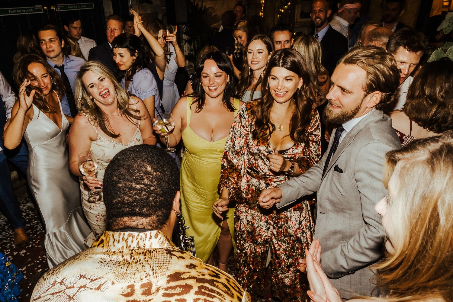 Energetic crowd dancing and celebrating at a nighttime party event.