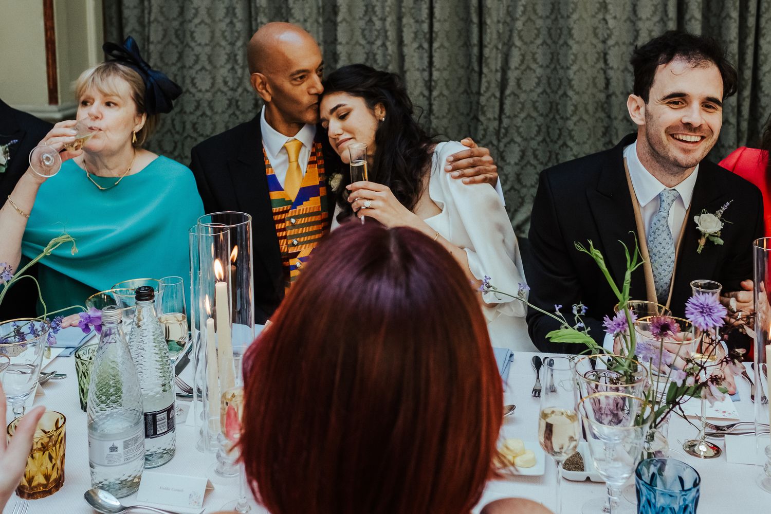 Guests engaged in lively conversation during an elegant indoor wedding reception.