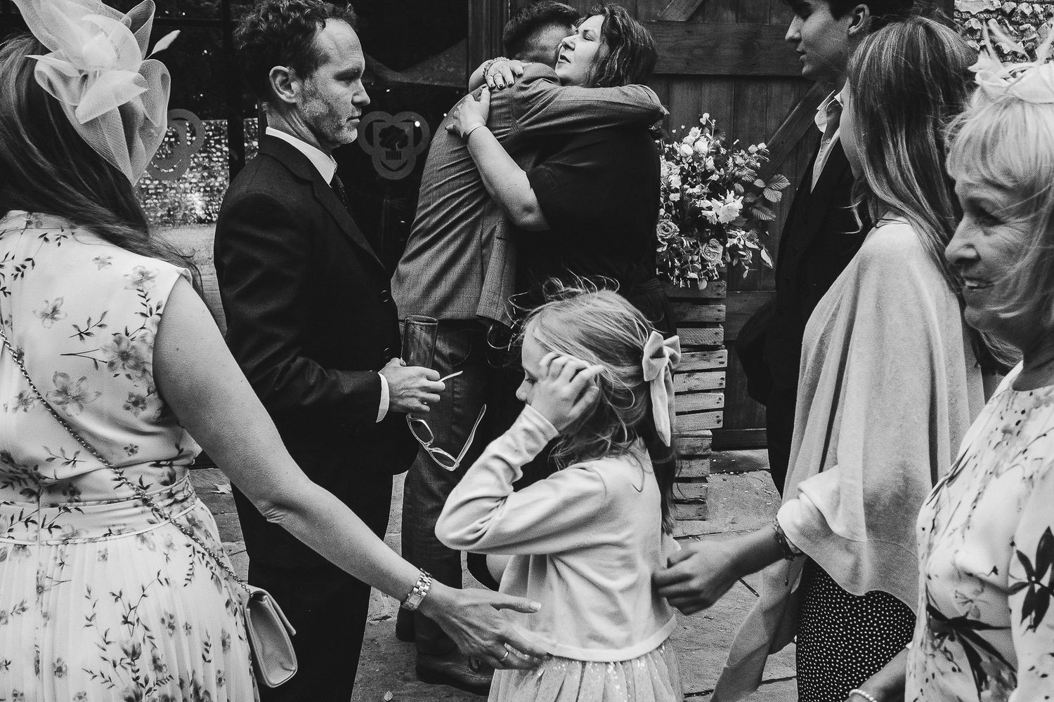 Black and white photo of wedding guests dancing and celebrating at reception.