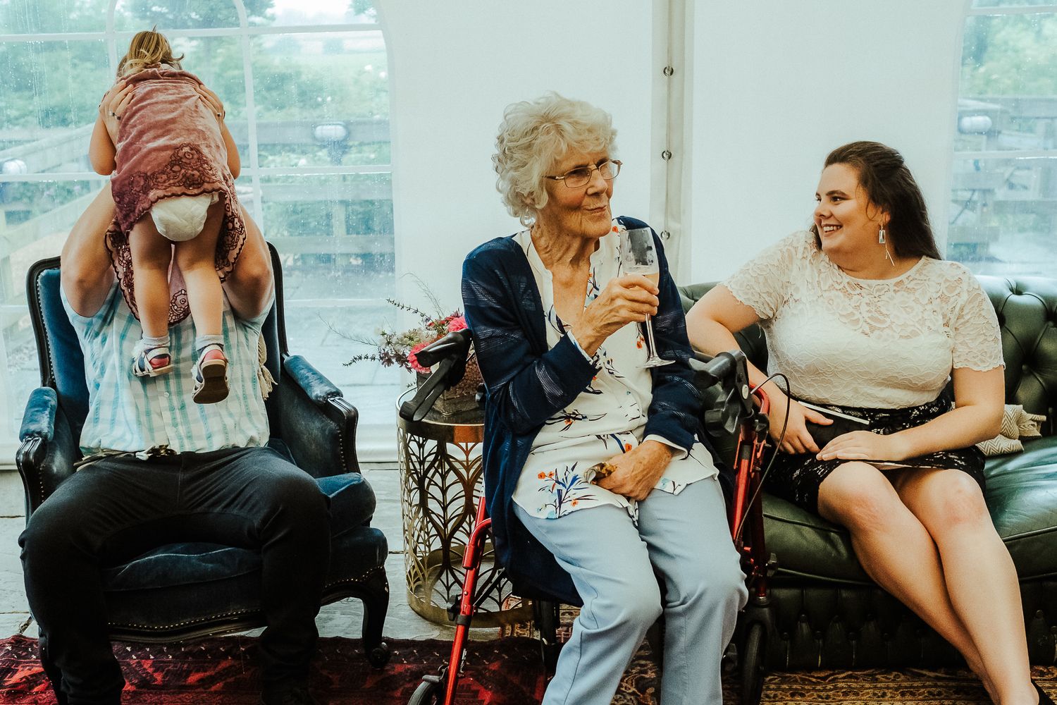 Wedding guests relax and socialize during an outdoor reception gathering.