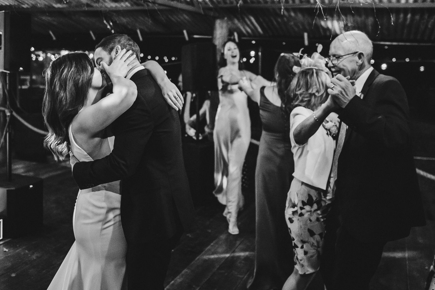 Black and white photo of couples dancing at a lively evening celebration.