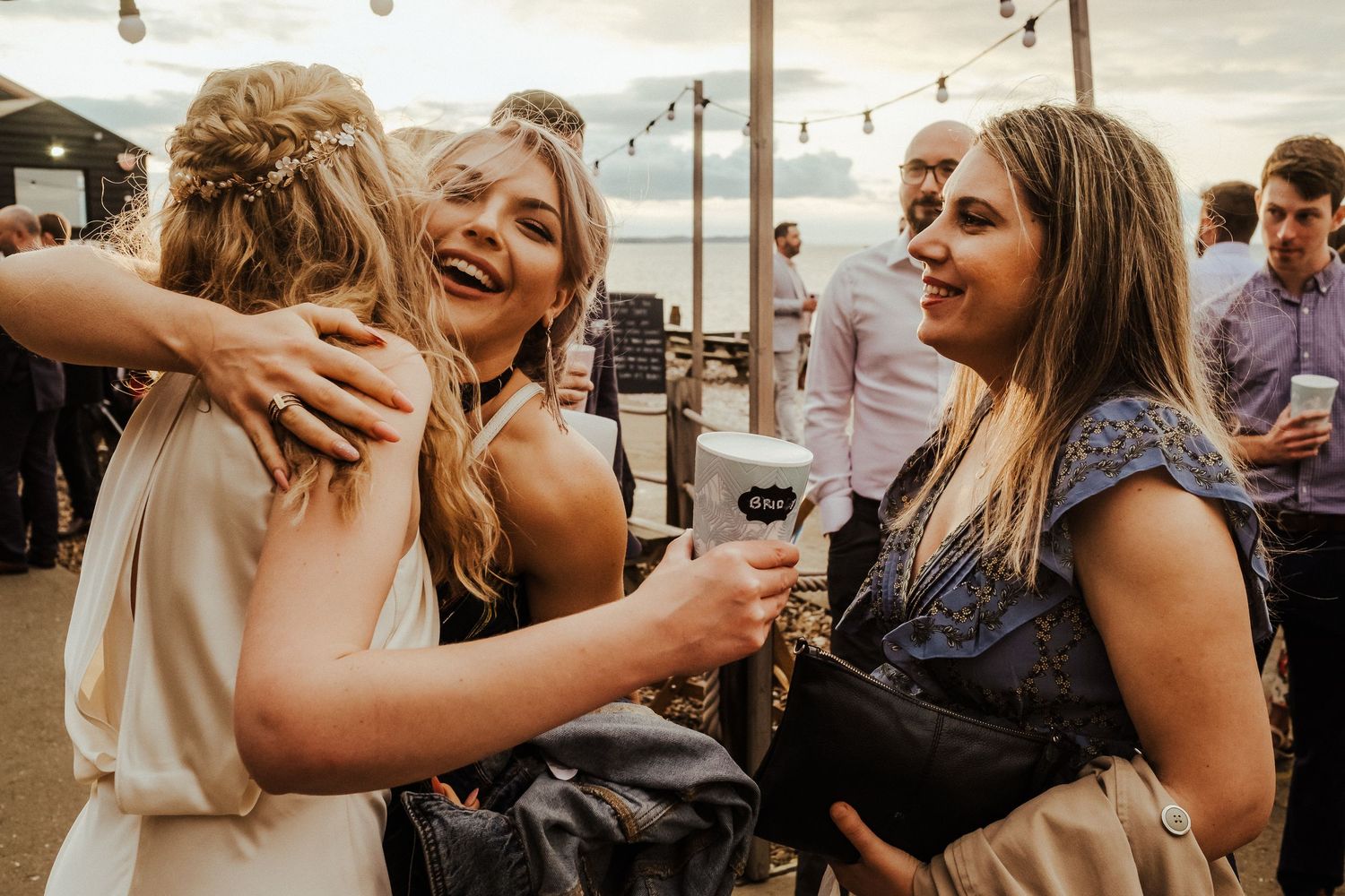 Candid moments of wedding guests laughing and embracing during reception celebrations.