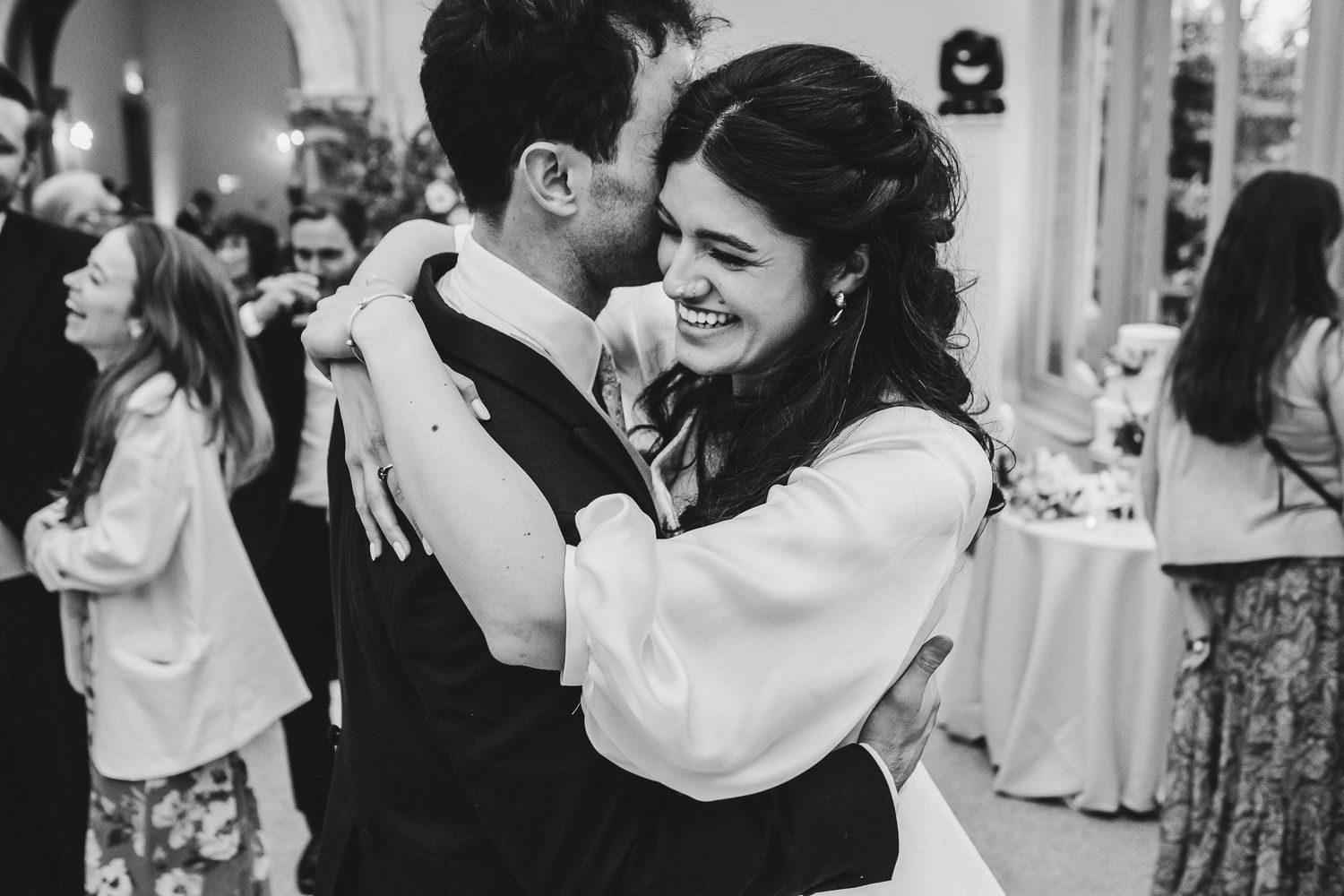 Black and white photo of a couple dancing together at their wedding reception.