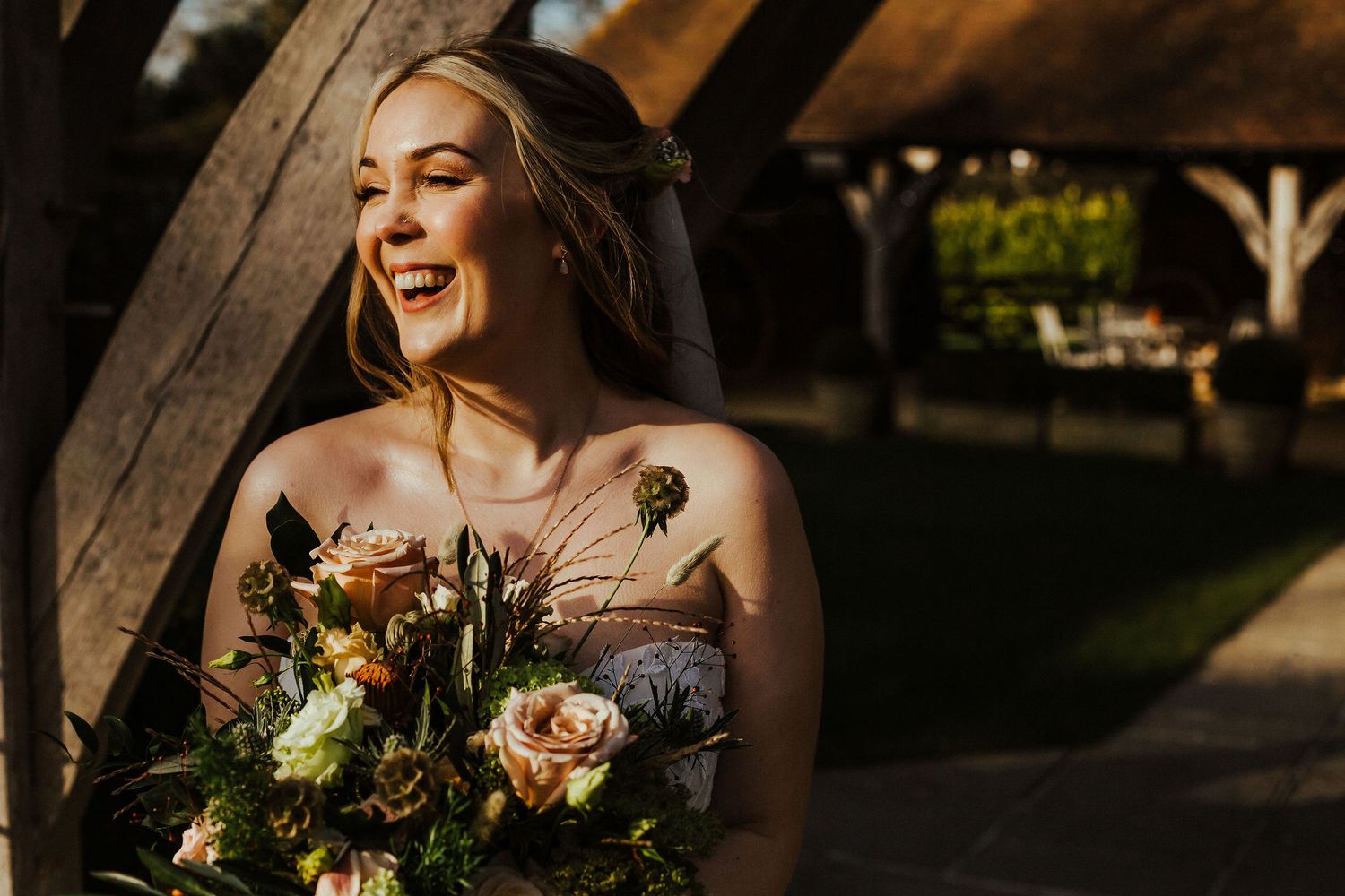 Wedding bouquet with autumn-colored flowers in golden sunlight.