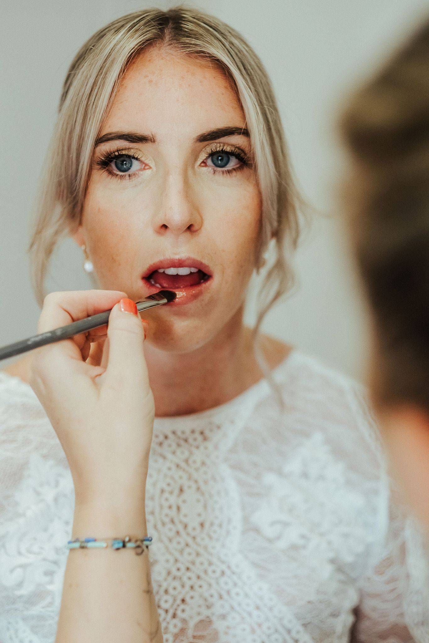 Close-up shots of makeup application showing lipstick detail and bridal preparation.