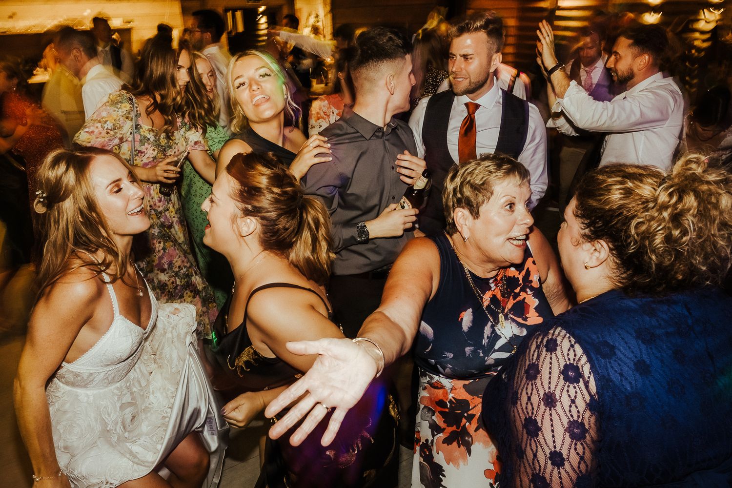 Lively wedding reception dance party with guests enjoying the celebration.