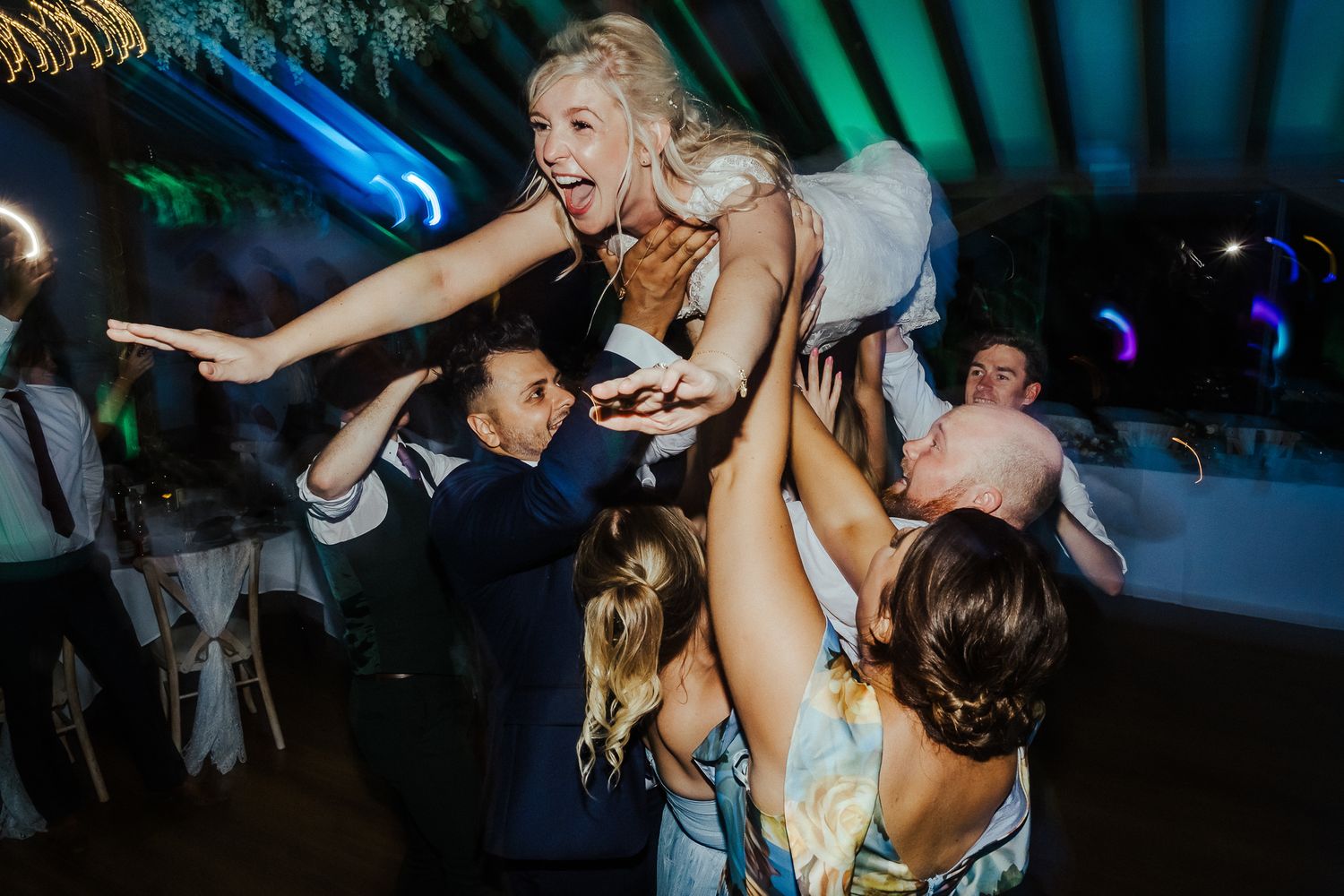 Energetic dance party with colorful lighting and guests celebrating on the dance floor.