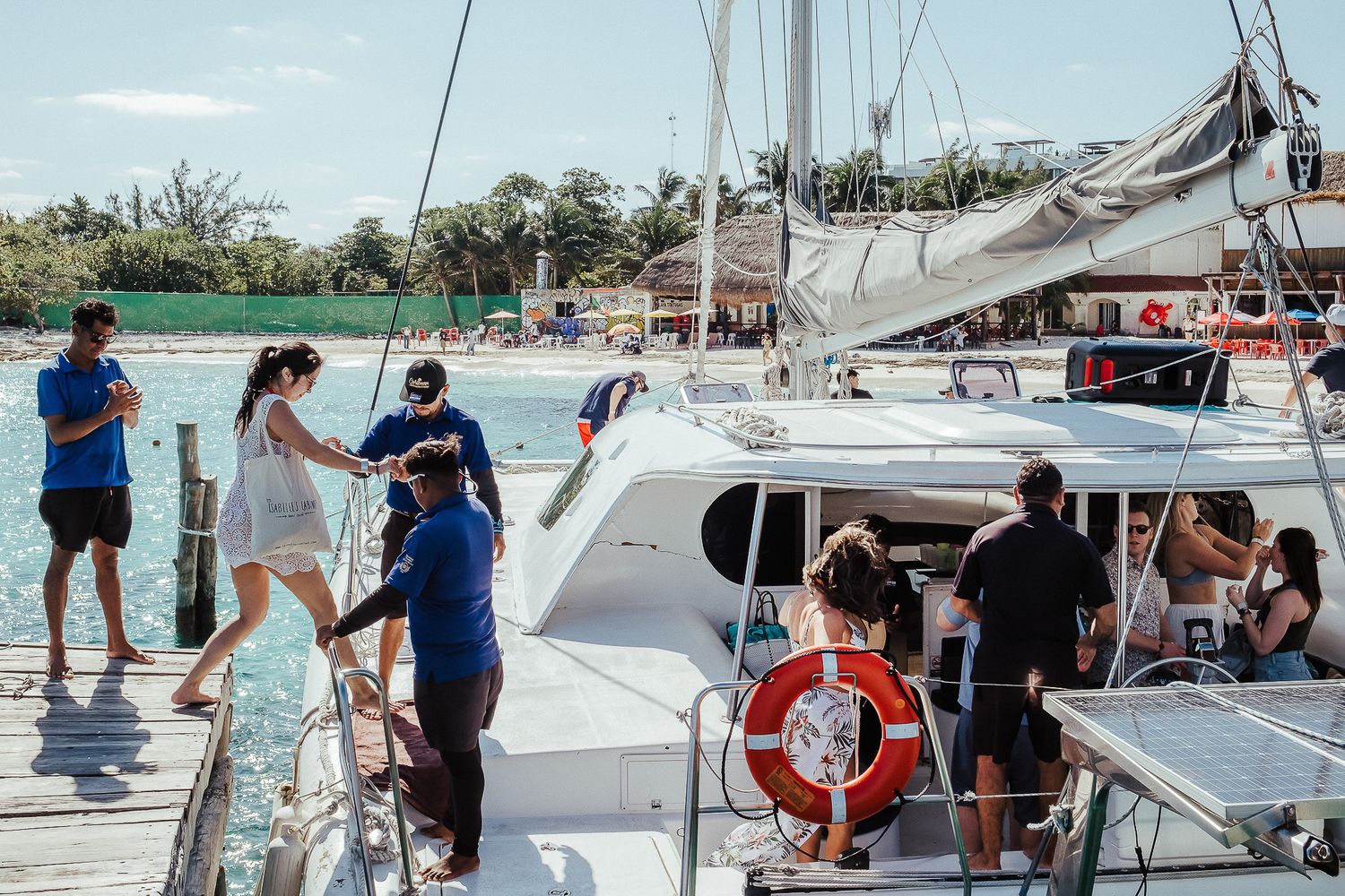Luxury catamaran boats docked at a tropical marina with clear blue waters.