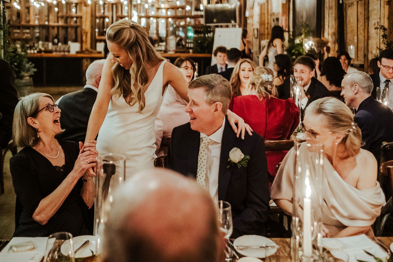Candid celebration moment captured during wedding reception dinner party.