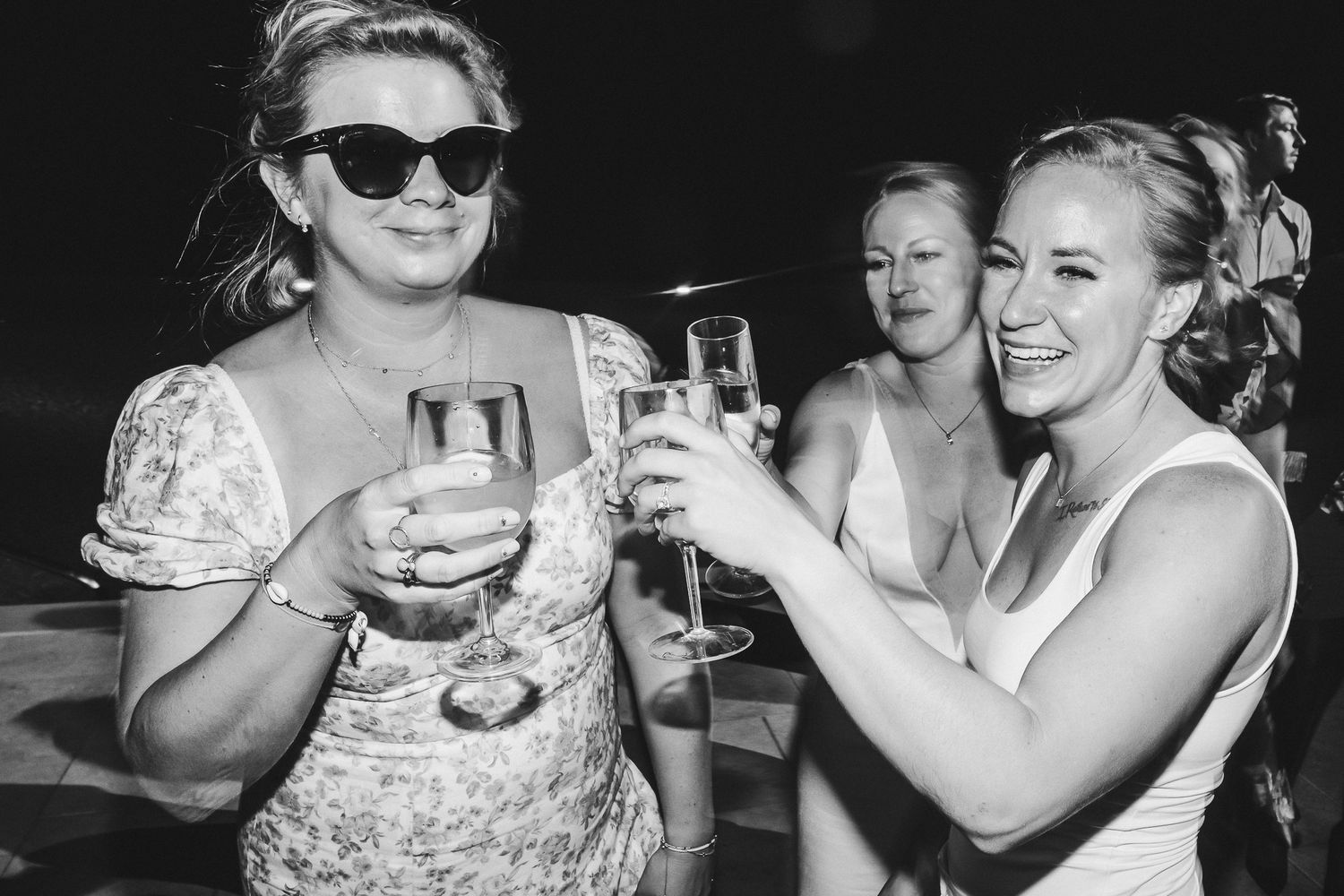 Two people toasting with champagne glasses at a celebratory outdoor event.