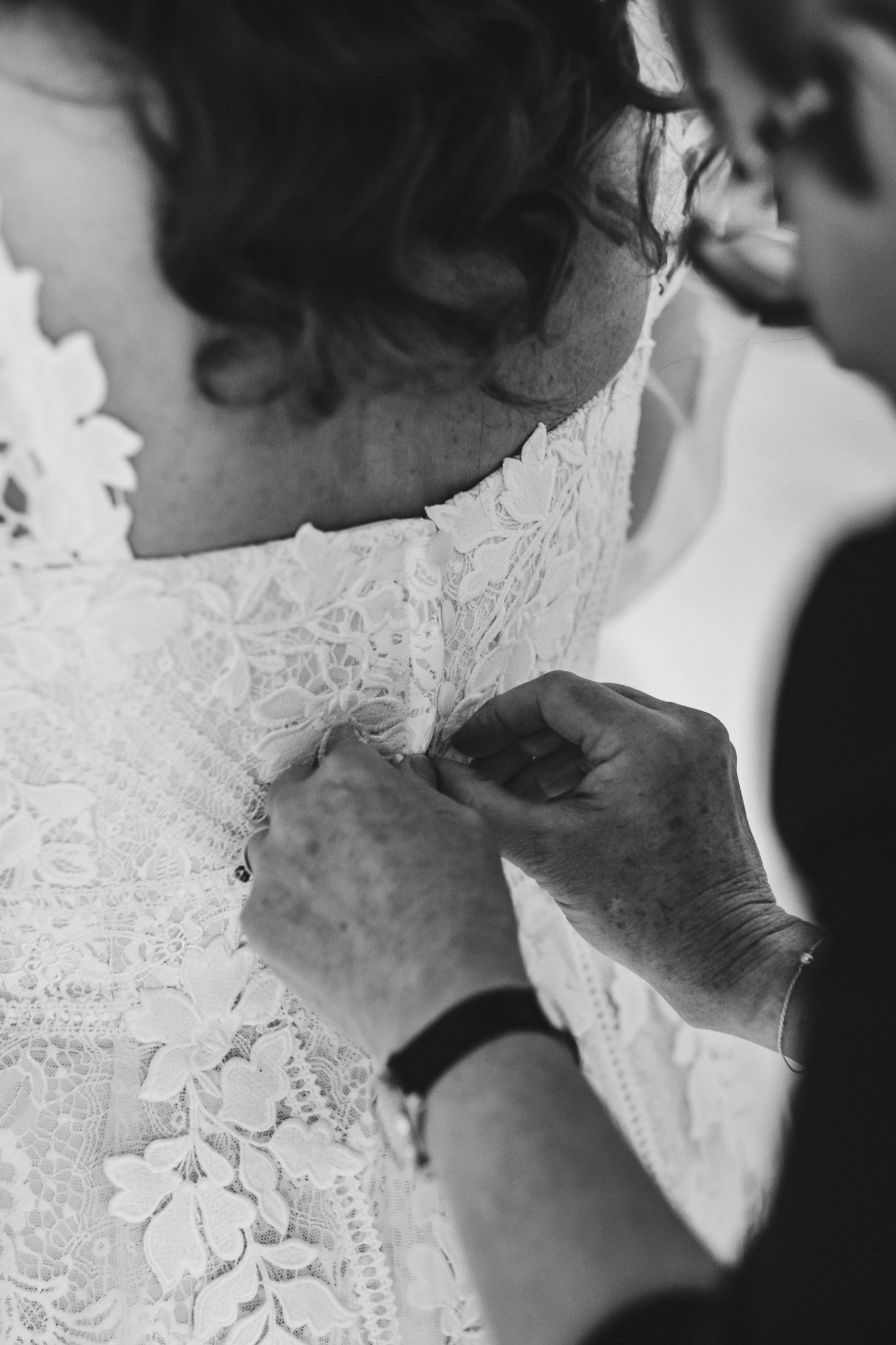 Close-up details of delicate white lace wedding dress details.