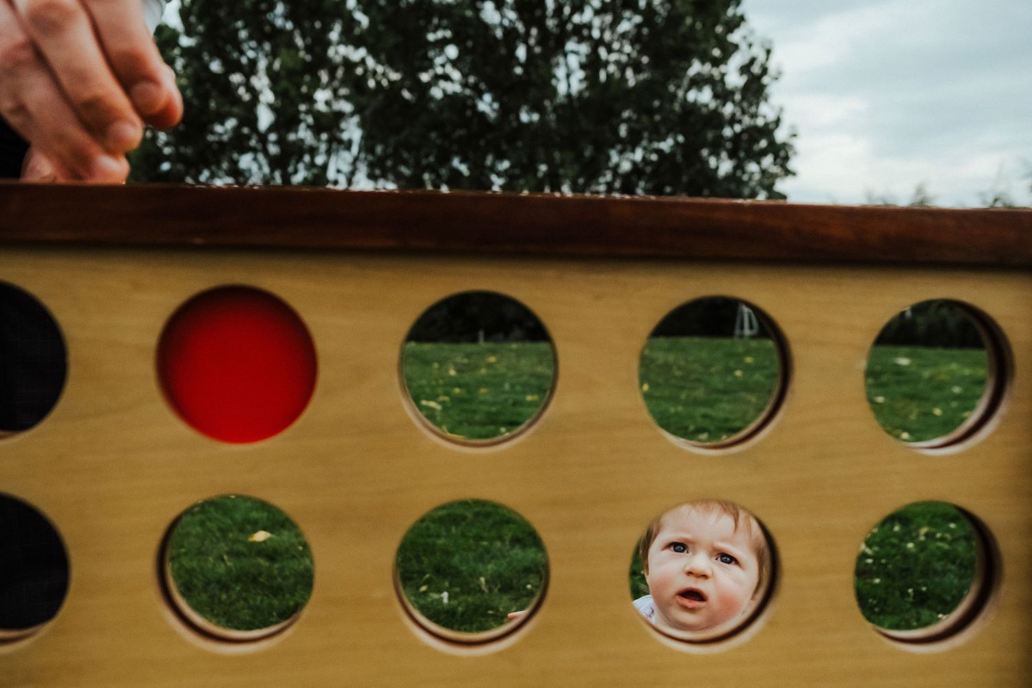 A playful moment captured through wooden circles at an outdoor event.