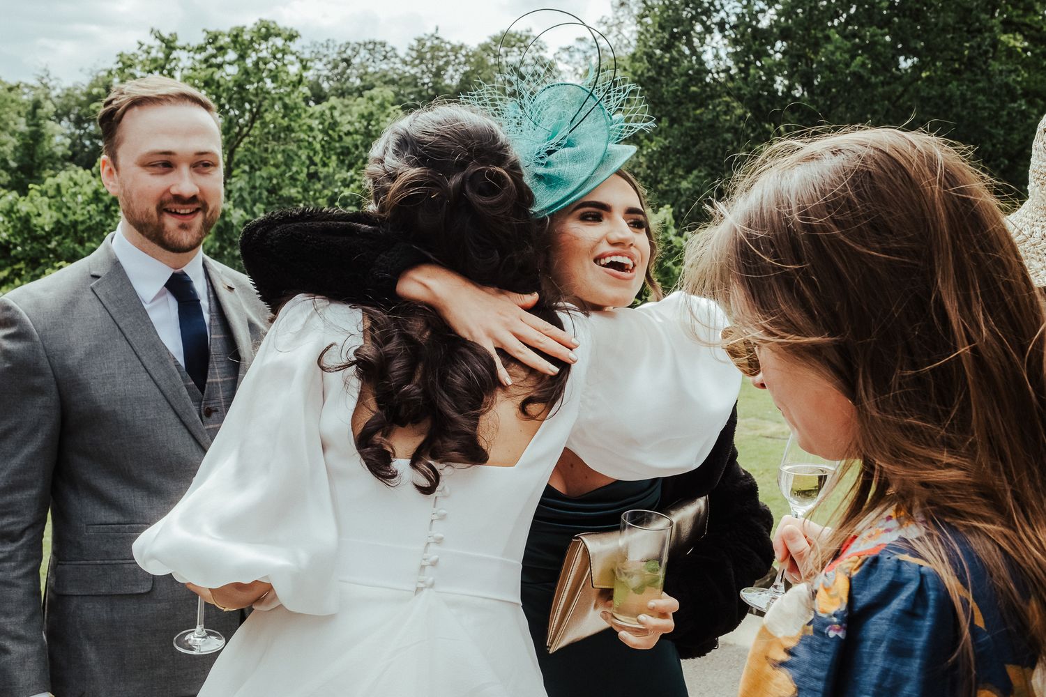 Joyful wedding celebration with guests toasting in a garden setting.