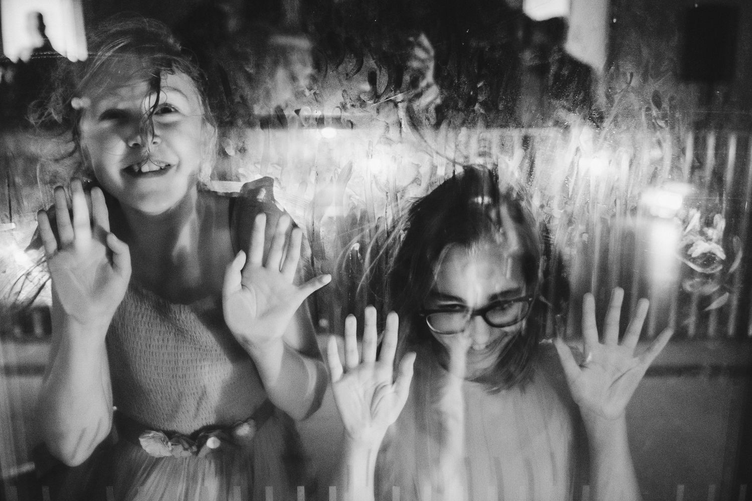 Two people playfully pose with hands up in vintage black and white photo.
