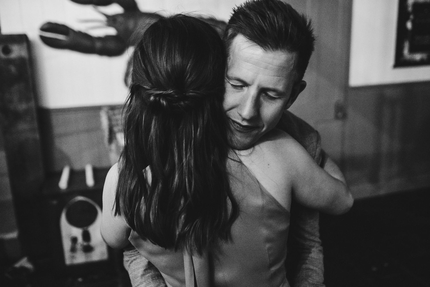 An intimate black and white moment of a couple embracing on their wedding day.