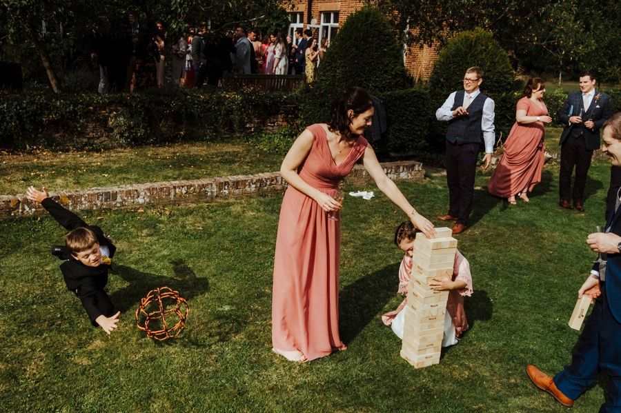 Wedding guests playing outdoor lawn games on a sunny day.