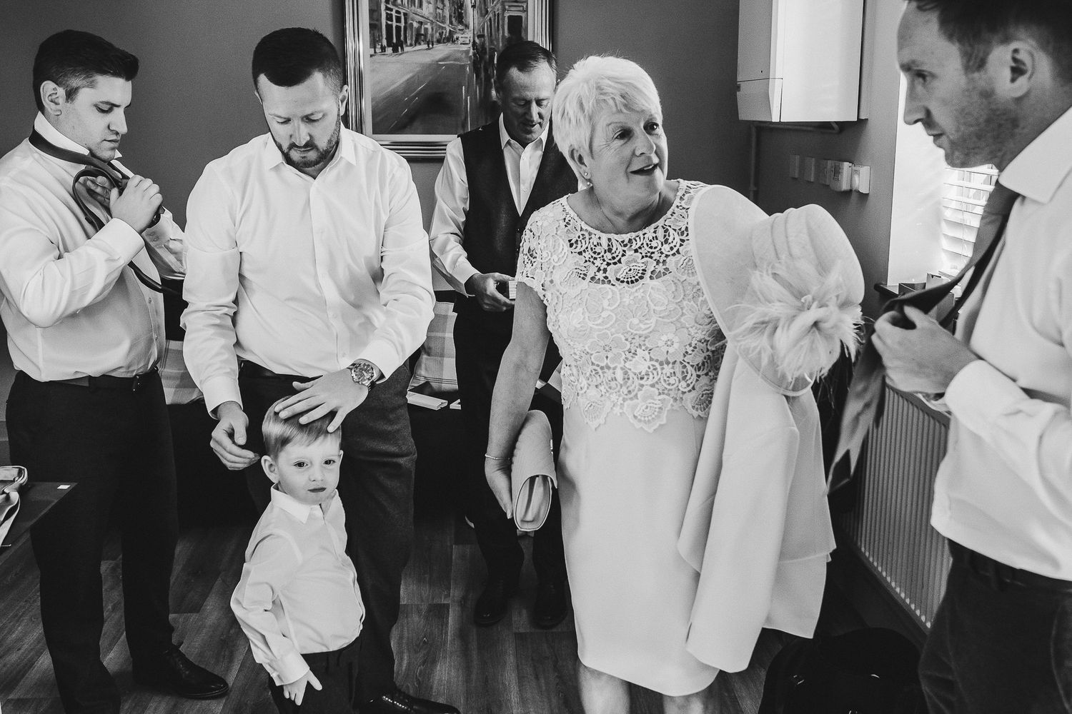 Black and white candid shot of wedding party dancing at reception.