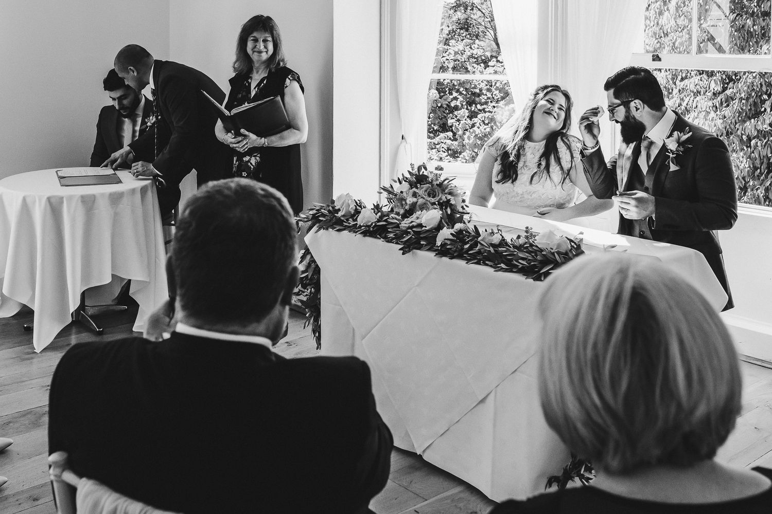 Wedding guests watching speeches during an indoor reception.