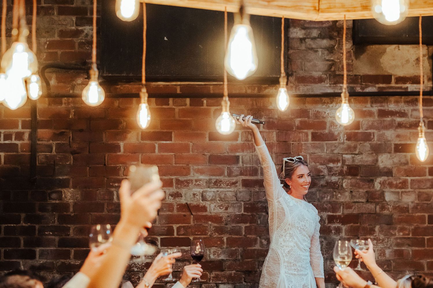 Wedding celebration in rustic venue with exposed brick walls and string lights.
