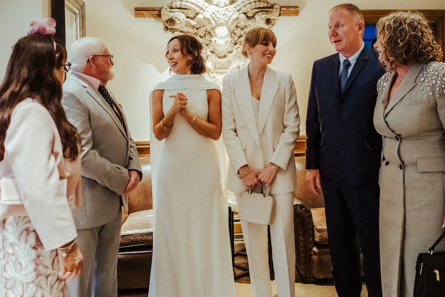 Wedding ceremony scene with couple and family members in formal attire.