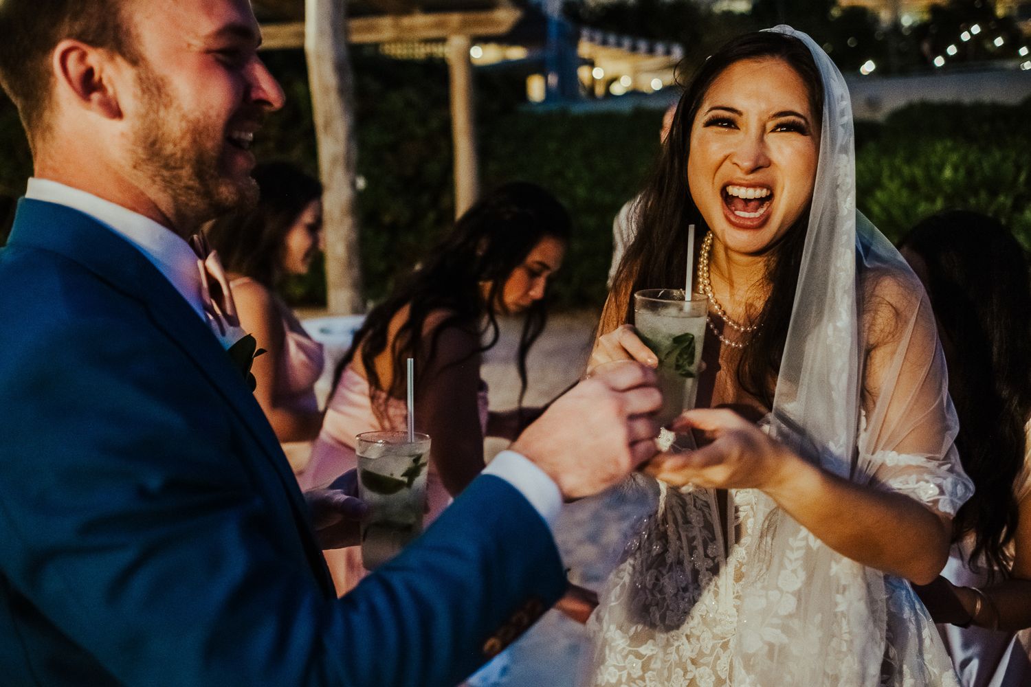 A joyful celebration moment between newlyweds during an outdoor wedding reception.