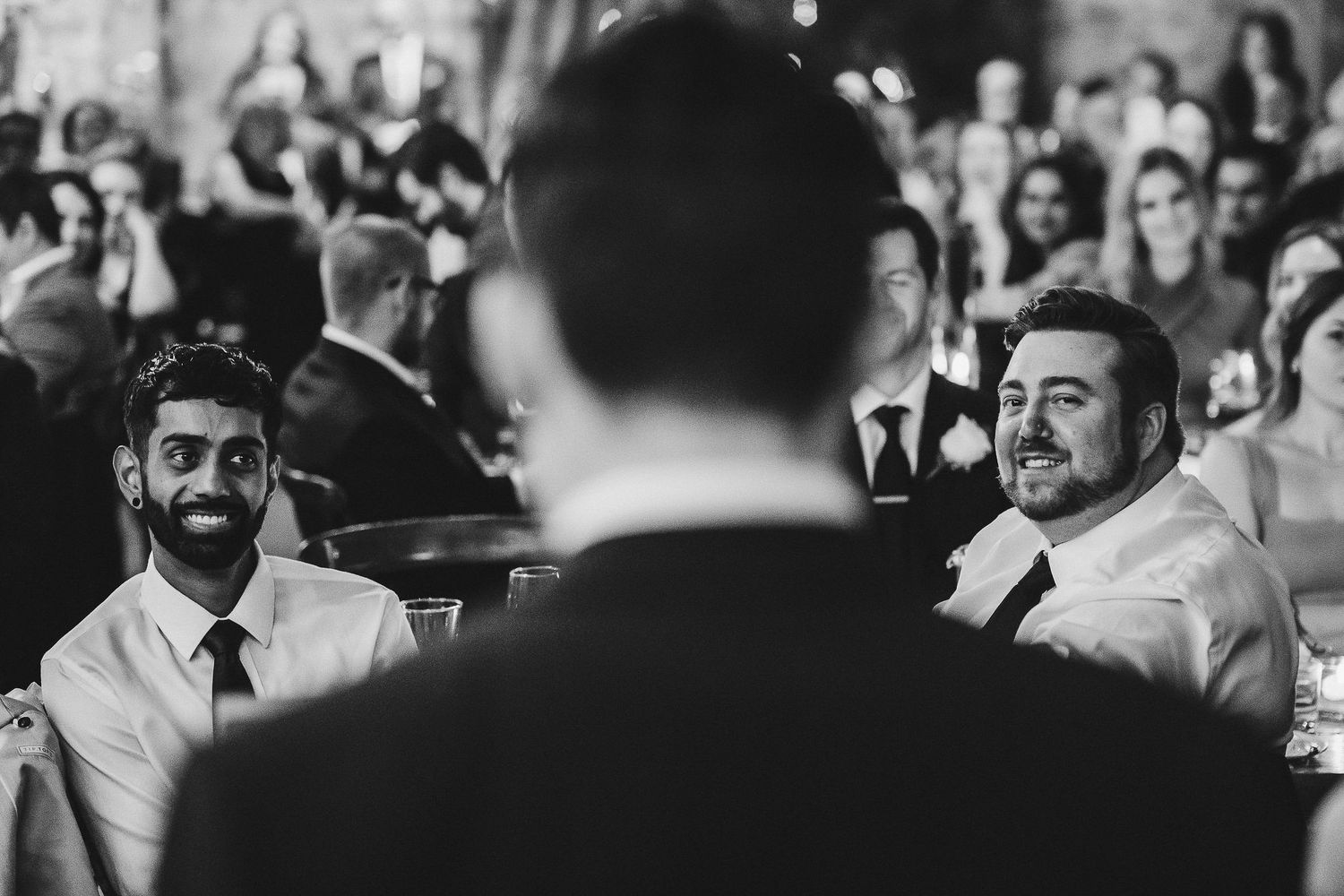 Black and white photo of audience members enjoying formal event presentation.