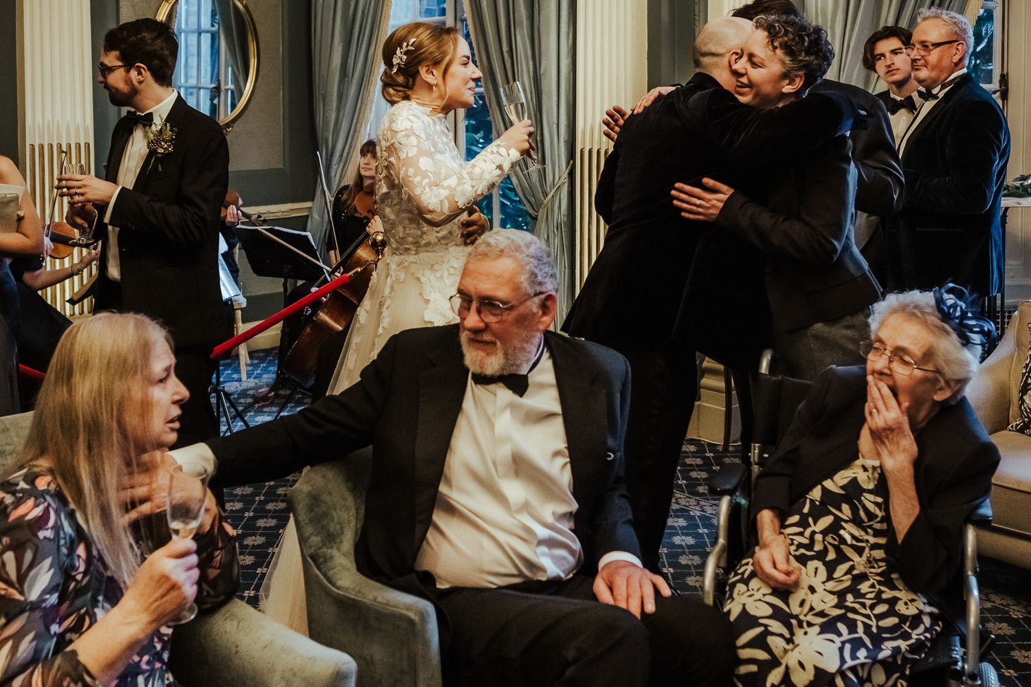 Wedding guests enjoying conversations and drinks during an elegant indoor reception.