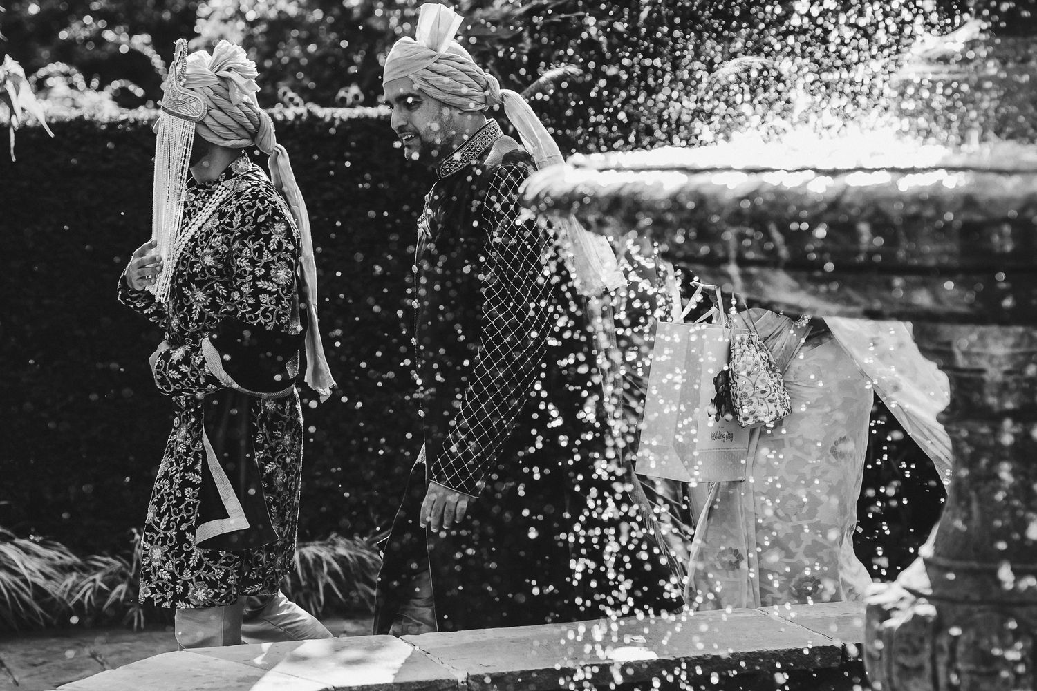 Black and white capture of playful water splashing during outdoor summer festivities.