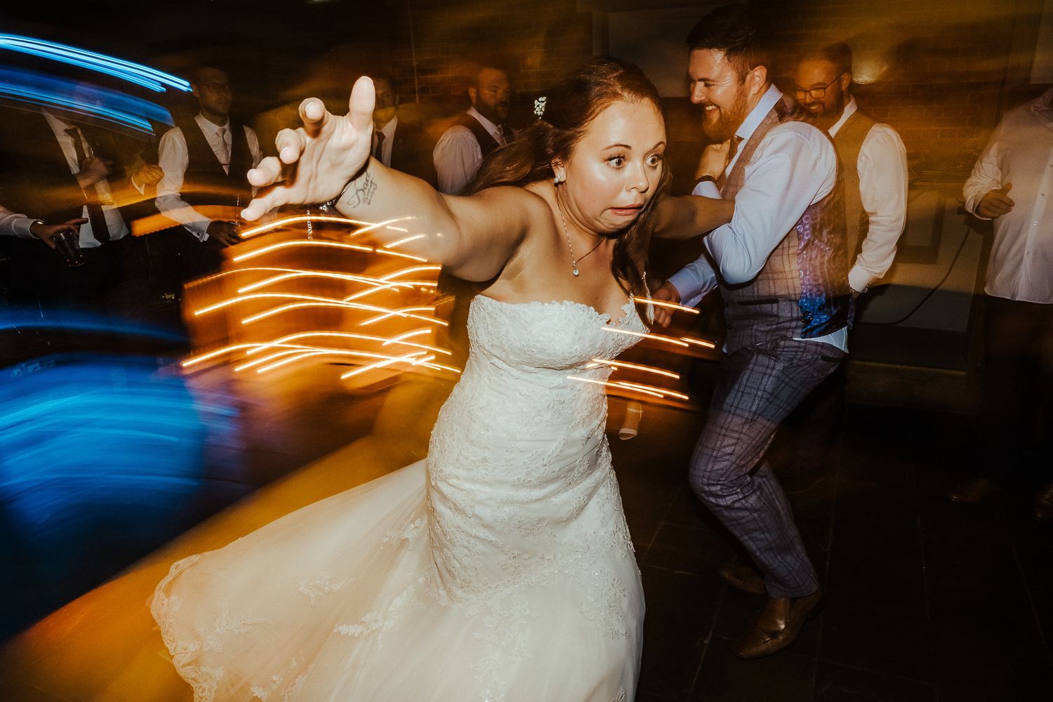 A wedding celebration with motion blur light trails creating a dynamic dancing atmosphere.