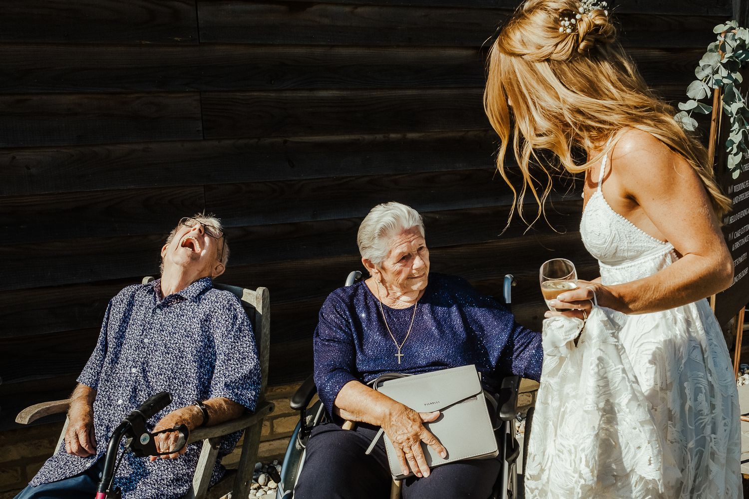 Wedding guests share a lighthearted moment during an outdoor celebration.