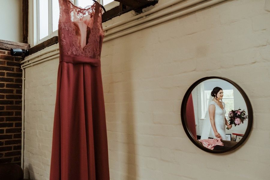 Wedding dress details and preparations shown in elegant frames and mirrors against a brick wall.